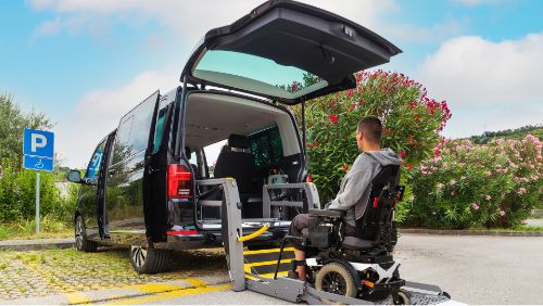 Alquilar un coche adaptado: Usuario de silla de ruedas entrando en un coche de alquiler adaptado mediante una rampa.