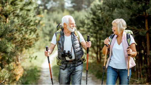 Mallorca para personas mayores: Pareja paseando con bastones de senderismo por la naturaleza mallorquina. Mallorca para personas mayores: Pareja paseando con bastones de senderismo por la naturaleza mallorquina.